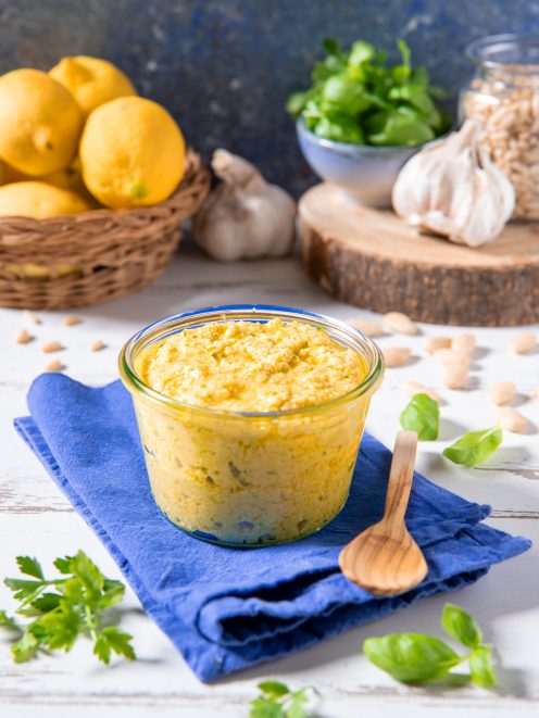 Pesto di limoni in vasetto con pinoli, aglio e foglie di basilico intorno