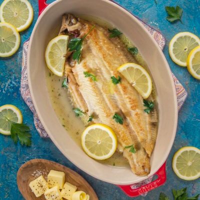 Sogliola alla mugnaia intera con salsa al burro, fette di limone e prezzemolo fresco