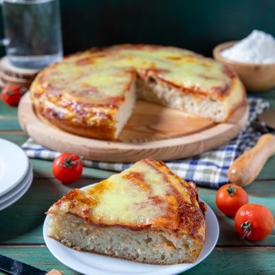 Pizza liquida con mozzarella filante e salsa di pomodoro, una fetta in primo piano che mostra l'impasto soffice e alveolato