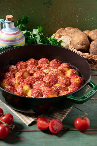 Cocule di patate salentine in padella con abbondante sugo di pomodoro e formaggio grattugiato