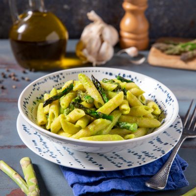Pasta con gli asparagi saltati e crema verde, servita in abbondante porzione