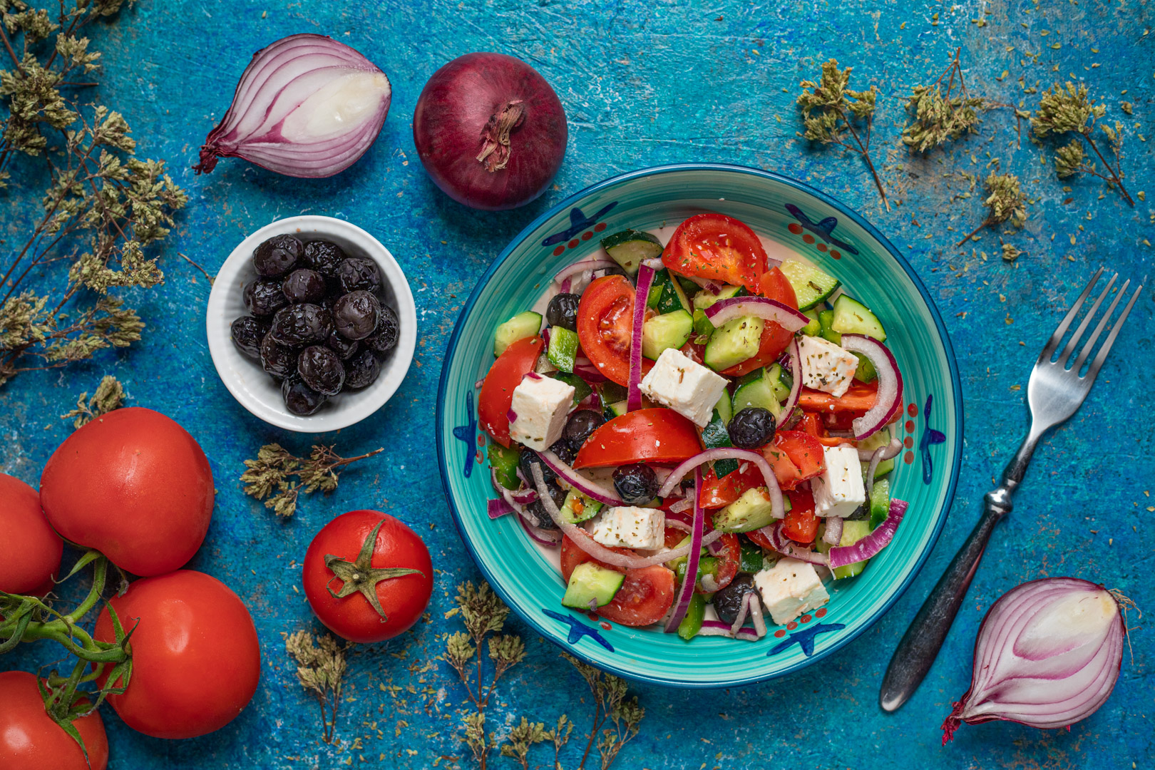Insalata greca con pomodori, cetrioli, feta a cubetti, olive nere e cipolla rossa