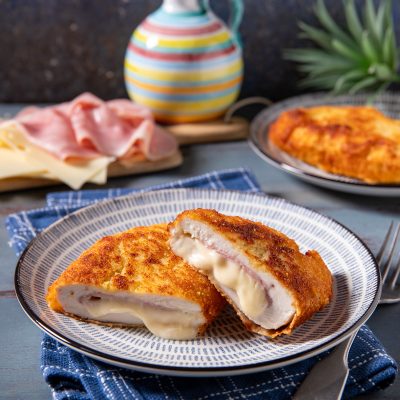 Cordon bleu di pollo tagliato a metà con formaggio filante e prosciutto cotto all'interno