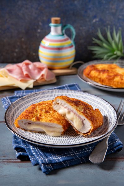 Cordon bleu di pollo tagliato a metà con formaggio filante e prosciutto cotto all'interno