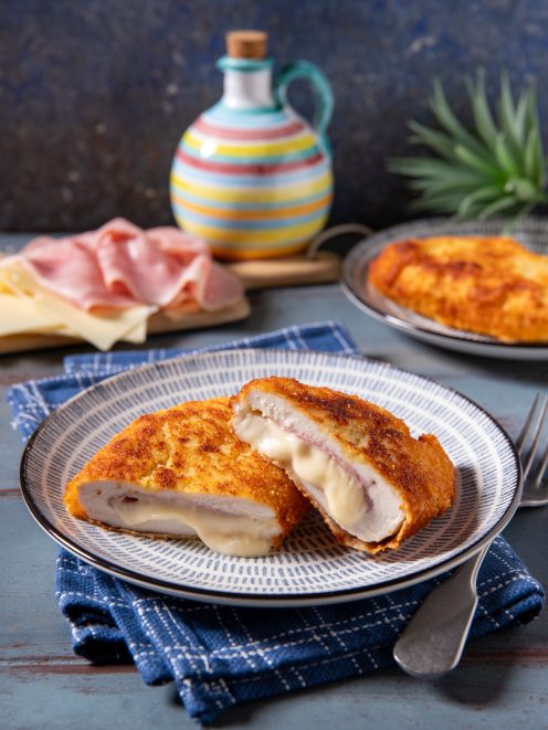 Cordon bleu di pollo tagliato a metà con formaggio filante e prosciutto cotto all'interno