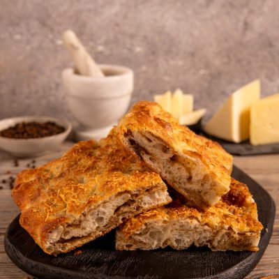Focaccia sfogliata cacio e pepe tagliata a fette con alveolatura irregolare in bella vista