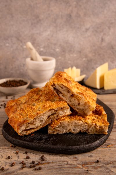 Focaccia sfogliata cacio e pepe tagliata a fette con alveolatura irregolare in bella vista