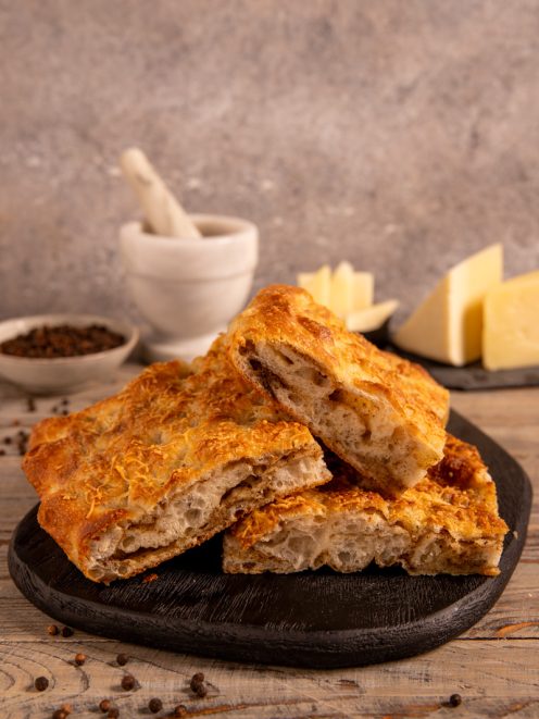 Focaccia sfogliata cacio e pepe tagliata a fette con alveolatura irregolare in bella vista