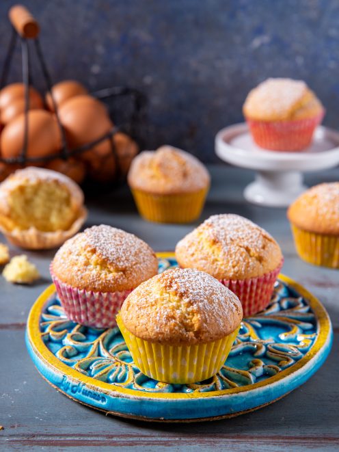 Muffin soffici spolverati di zucchero a velo, serviti nei pirottini colorati