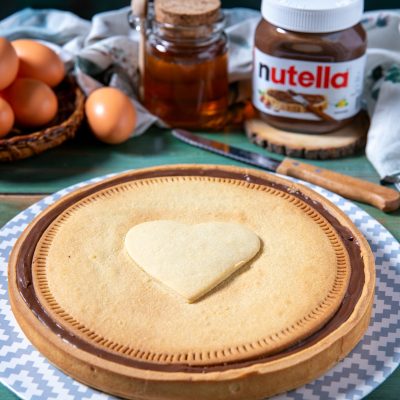 Nutella Biscuits Cake con copertura di crema al cioccolato e biscotto a cuore al centro