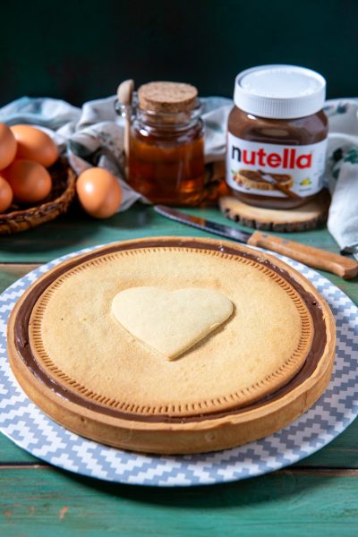 Nutella Biscuits Cake con copertura di crema al cioccolato e biscotto a cuore al centro