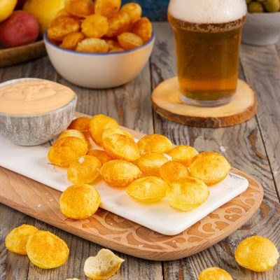 Patate soffiate dorate e croccanti servite con salsa rosa per l'aperitivo