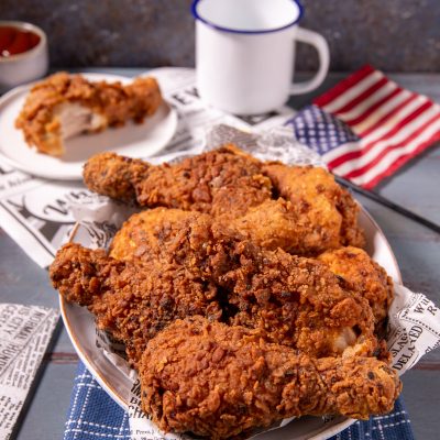 Pollo fritto in stile KFC con crosta dorata e croccante, servito con pezzi sovrapposti