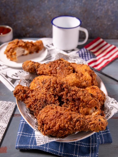 Pollo fritto in stile KFC con crosta dorata e croccante, servito con pezzi sovrapposti