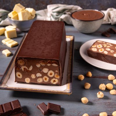 Torrone dei morti a fette con nocciole intere immerse nel cioccolato fondente