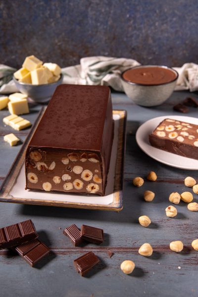 Torrone dei morti a fette con nocciole intere immerse nel cioccolato fondente
