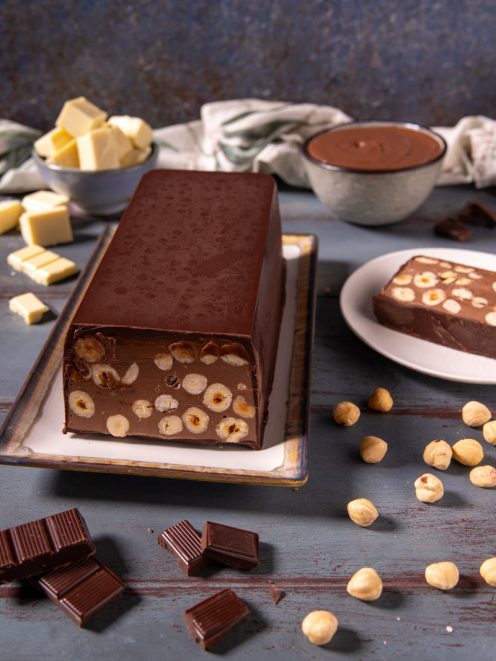 Torrone dei morti a fette con nocciole intere immerse nel cioccolato fondente