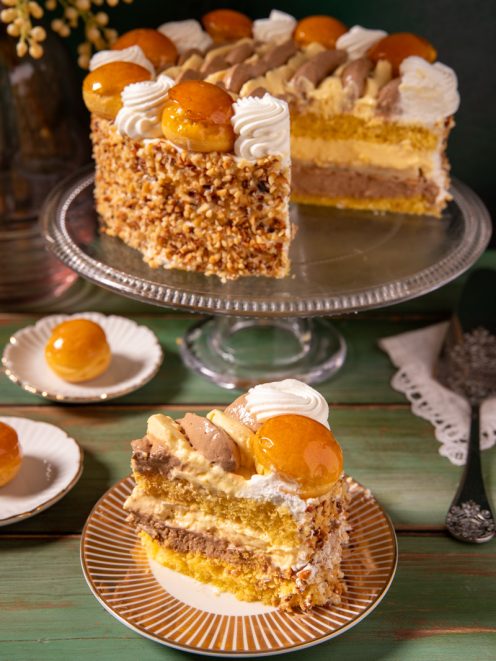 Torta Saint Honoré a strati con crema, bignè caramellati, granella di nocciole e ciuffi di panna