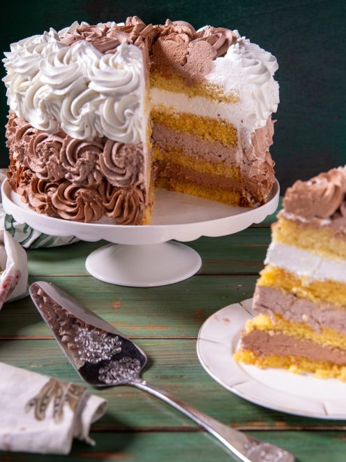 Torta farcita con panna e crema al cioccolato, tagliata a fette con strati di pan di Spagna in vista