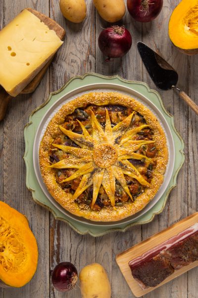 Torta salata girasole con decoro a petali di pasta sfoglia, semi di sesamo e ripieno di zucca e patate