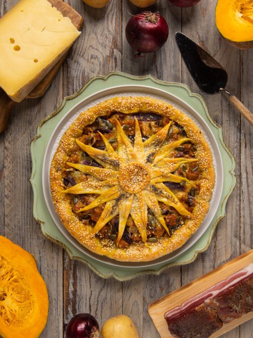 Torta salata girasole con decoro a petali di pasta sfoglia, semi di sesamo e ripieno di zucca e patate
