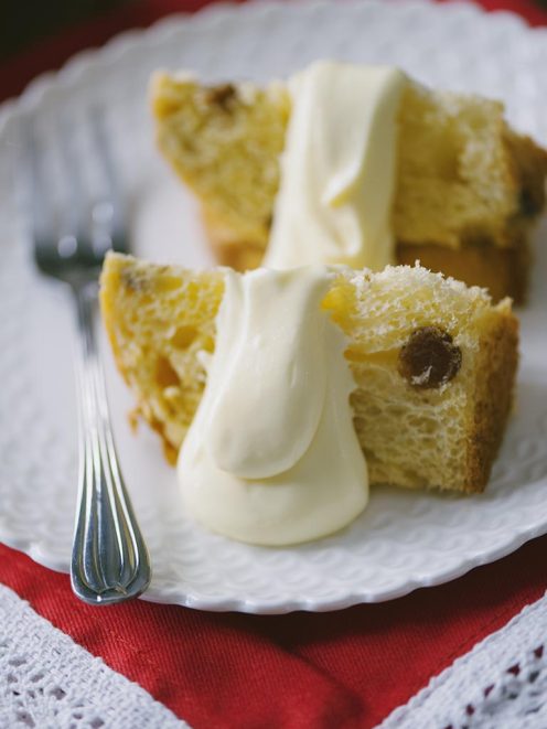 Crema al mascarpone vellutata servita a cucchiaiate su fette di panettone soffice con uvetta