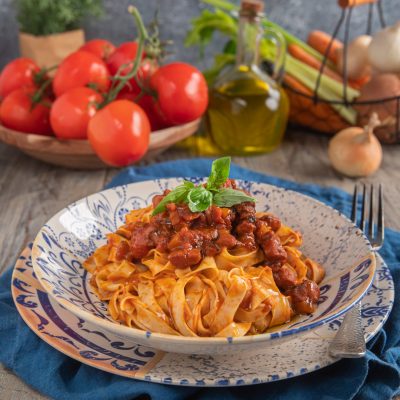 Tagliatelle al ragù di polpo con sugo di pomodoro a pezzetti di polpo e una fogliolina di basilico fresco in cima