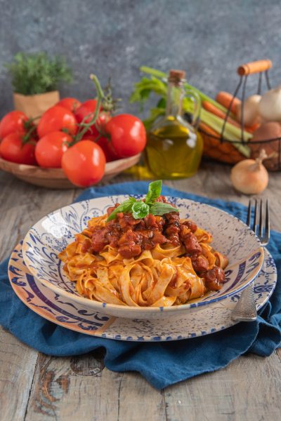 Tagliatelle al ragù di polpo con sugo di pomodoro a pezzetti di polpo e una fogliolina di basilico fresco in cima