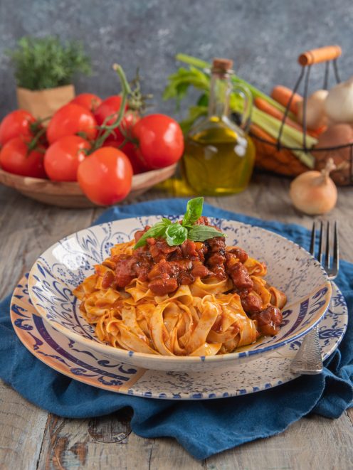 Tagliatelle al ragù di polpo con sugo di pomodoro a pezzetti di polpo e una fogliolina di basilico fresco in cima